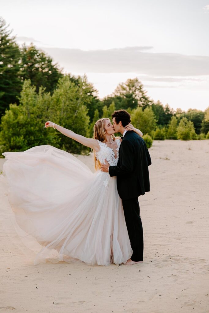 couple in the sand in maine elopement