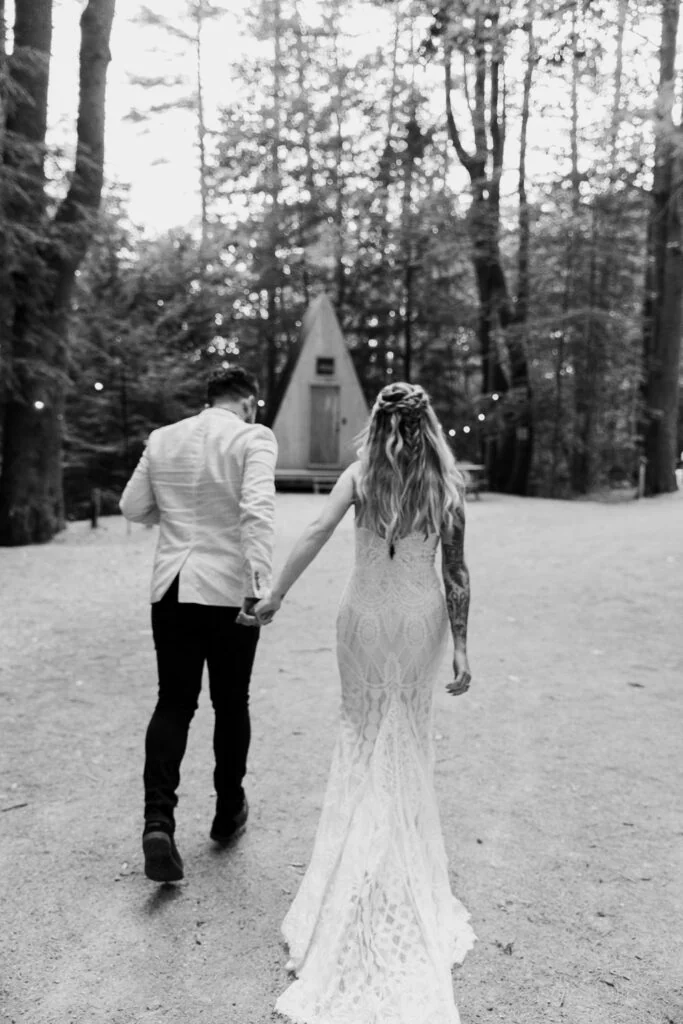 A newly married couple walking together with trees behind them