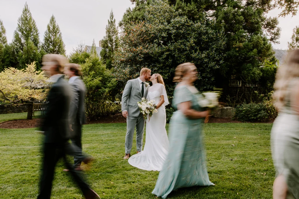 Newlyweds among their wedding guests on a lawn